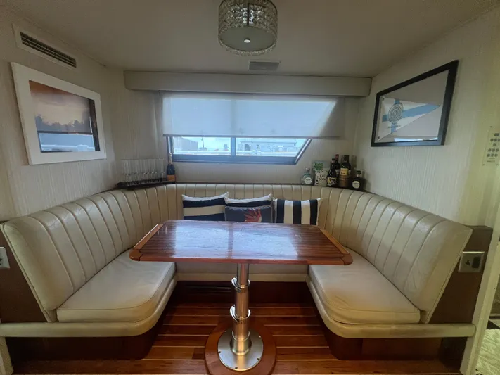 Havana Moon Yacht Photos Pics Interior of 1990 Hatteras 70 Cockpit Motor Yacht with cozy dining area and wooden table.