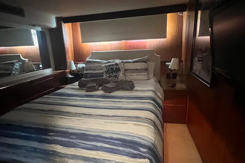 Havana Moon Yacht Photos Pics Cozy bedroom in 1990 Hatteras 70 Cockpit Motor Yacht with striped bedding.