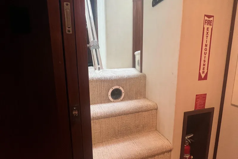 Havana Moon Yacht Photos Pics Staircase inside 1990 Hatteras 70 Cockpit Motor Yacht with fire extinguisher.