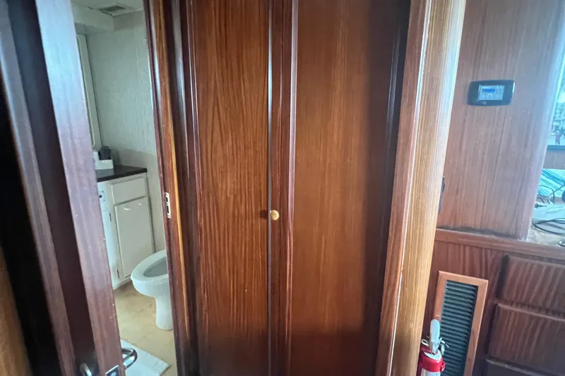 Havana Moon Yacht Photos Pics Interior of 1990 Hatteras 70 Cockpit Motor Yacht with wooden cabinetry and bathroom view.