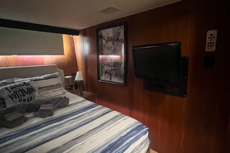 Havana Moon Yacht Photos Pics Cozy bedroom in 1990 Hatteras 70 Cockpit Motor Yacht with TV and striped bedding.