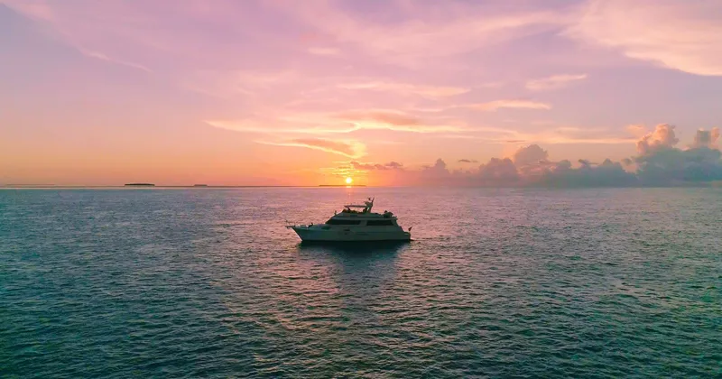 Havana Moon Yacht Photos Pics Hatteras 70 Cockpit Motor Yacht, 1990, cruising at sunset on open sea.