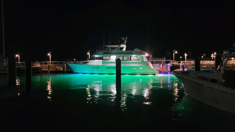 Havana Moon Yacht Photos Pics Hatteras 70 Cockpit Motor Yacht 1990 illuminated at night in marina.