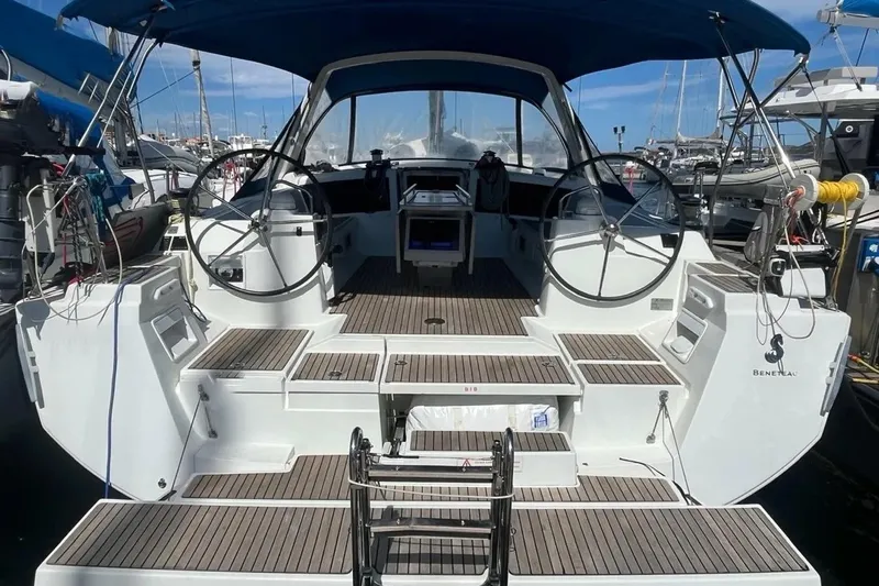 Yacht Photos Pics 2018 Beneteau Oceanis 48 yacht with dual steering wheels, docked at a marina.