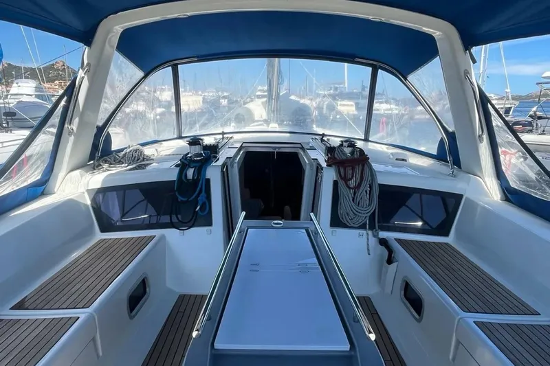  Yacht Photos Pics Cockpit of 2018 Beneteau Oceanis 48 sailboat with blue canopy and teak seating.