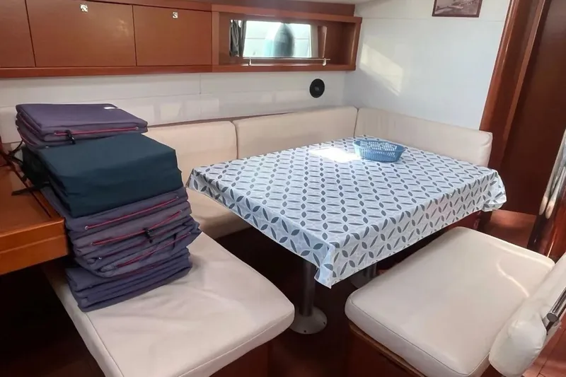  Yacht Photos Pics Interior of 2018 Beneteau Oceanis 48 yacht with dining area and cushioned seating.