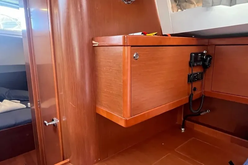  Yacht Photos Pics Interior of 2018 Beneteau Oceanis 48 yacht with wooden cabinetry and communication equipment.