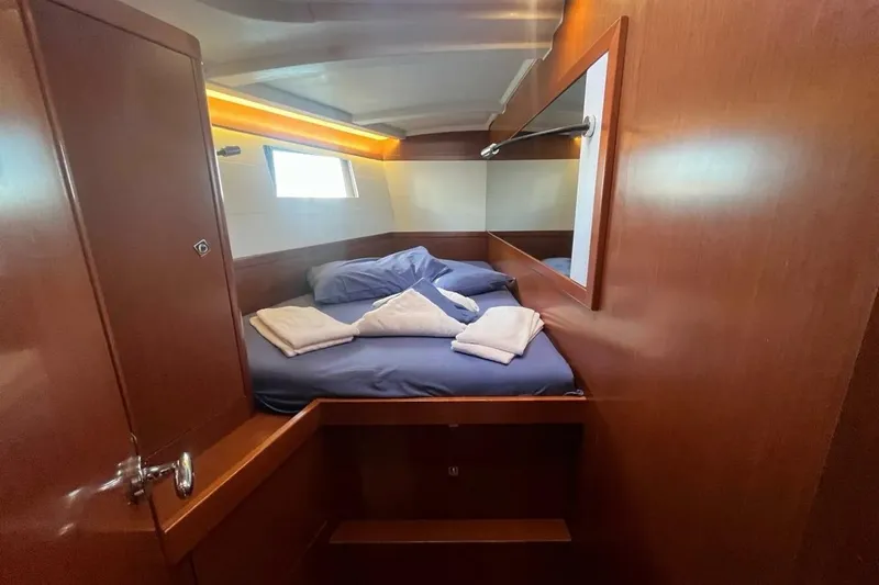  Yacht Photos Pics Cabin interior of 2018 Beneteau Oceanis 48 with cozy bed and wooden finish.