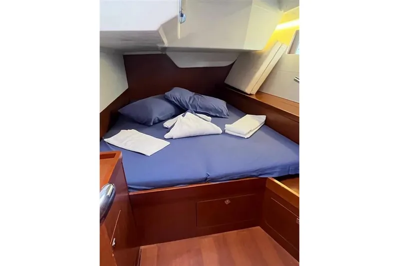  Yacht Photos Pics Cozy cabin interior of 2018 Beneteau Oceanis 48 yacht with blue bedding.