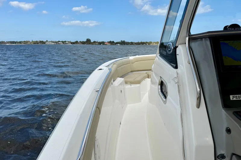  Yacht Photos Pics 2019 Pursuit S 328 Sport boat cruising on open water under blue sky.