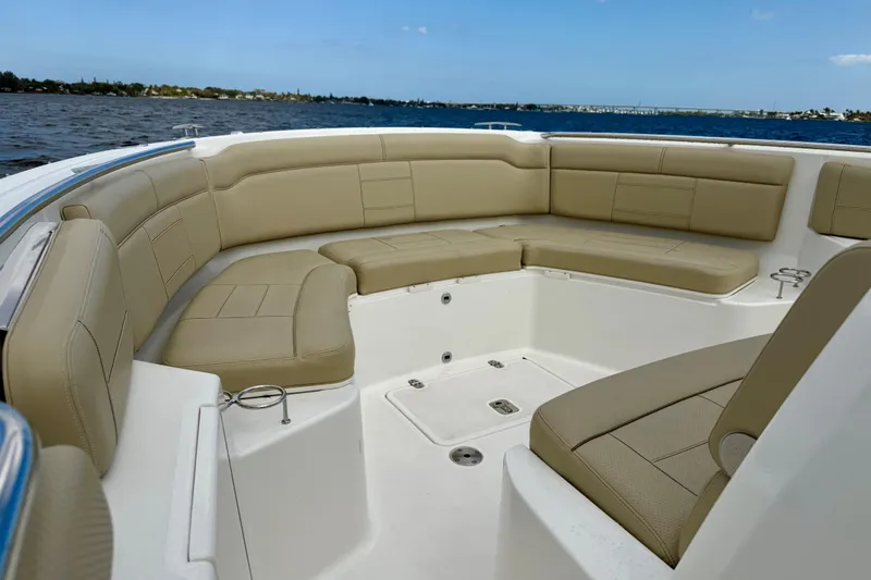  Yacht Photos Pics 2019 Pursuit S 328 Sport boat with beige seating, cruising on a calm lake.