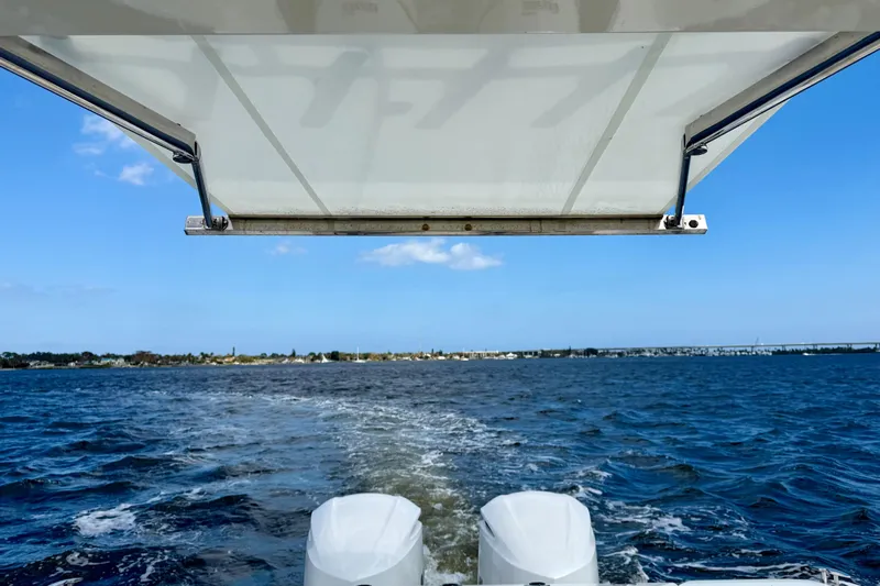  Yacht Photos Pics 2019 Pursuit S 328 Sport boat cruising on open water under a clear blue sky.