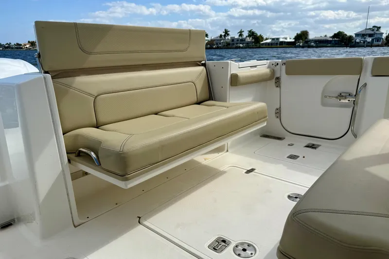  Yacht Photos Pics 2019 Pursuit S 328 Sport boat interior with beige seating, ocean view in background.