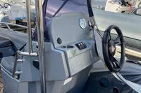 2020 Grand G420 boat console with steering wheel and controls, docked outdoors.