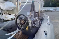 Inflatable boat Grand G420, 2020 model, with steering wheel and control panel, parked outdoors.