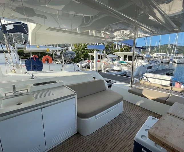 Kowi Kai Yacht Photos Pics Spacious deck of 2020 Lagoon 50 catamaran docked at marina with seating and kitchenette.