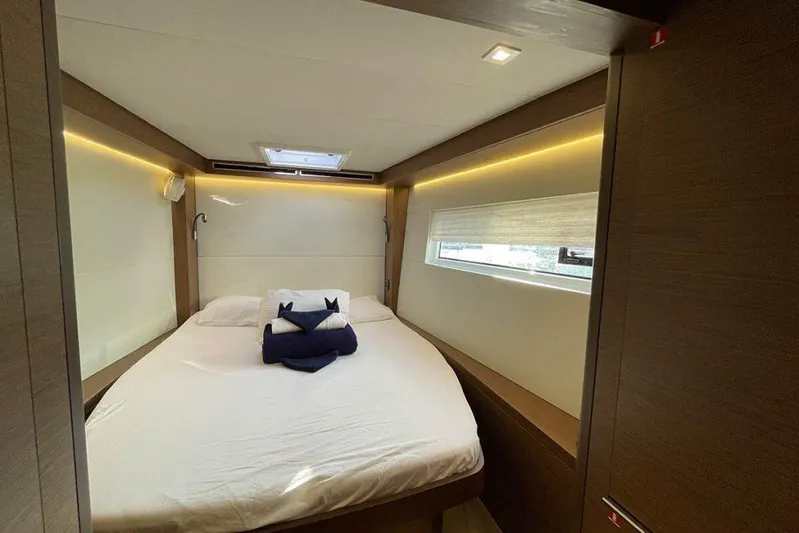 Kowi Kai Yacht Photos Pics Luxurious cabin interior of 2020 Lagoon 50 yacht with cozy bed and modern lighting.