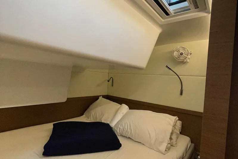 Kowi Kai Yacht Photos Pics Cozy cabin interior of 2020 Lagoon 50 yacht with bed, pillows, and reading lights.
