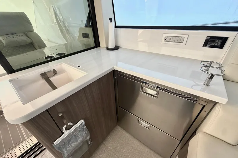  Yacht Photos Pics 2022 Regal 38 XO yacht interior with modern kitchenette and stainless steel appliances.