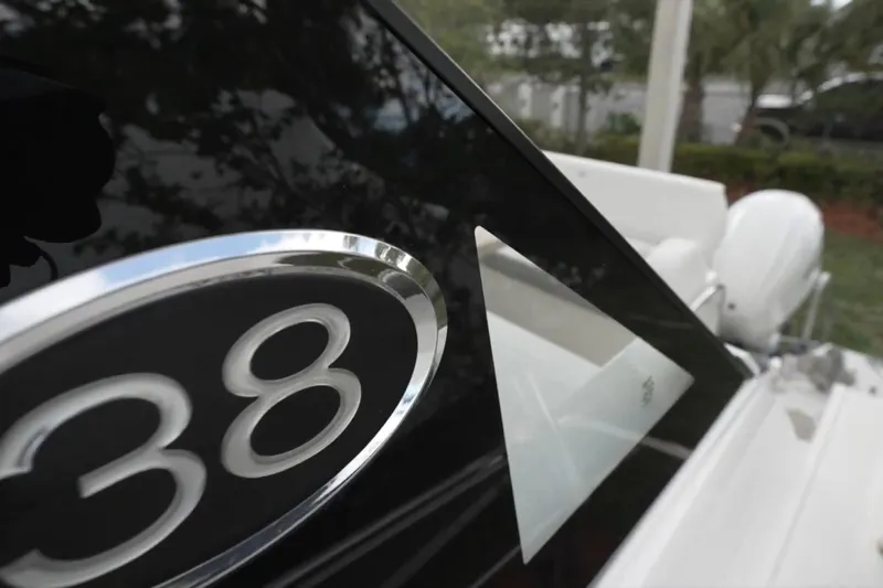  Yacht Photos Pics Close-up of 2022 Regal 38 XO boat emblem and sleek design details.