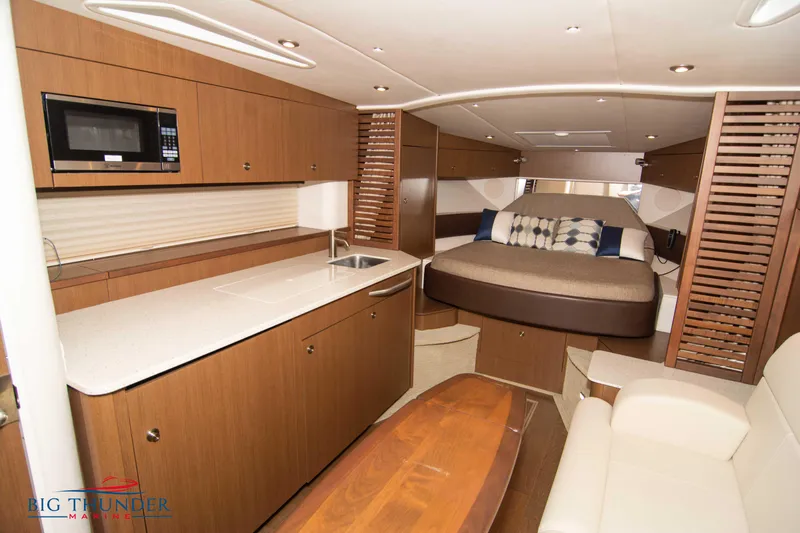  Yacht Photos Pics Luxurious interior of 2016 Sea Ray 370 Sundancer yacht with modern kitchen and cozy sleeping area.