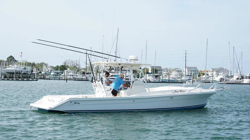  Yacht Photos Pics A 2016 Strike 35 boat on water near a marina, with fishing rods visible.