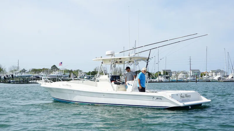  Yacht Photos Pics 2016 Strike 35 boat on water with two people, fishing rods, and marina background.