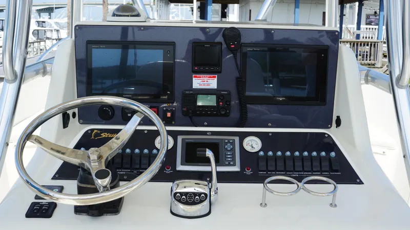  Yacht Photos Pics Control panel of a 2016 Strike 35 boat with steering wheel and navigation screens.