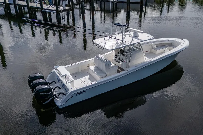 Yacht Photos Pics 2016 Invincible 39 Open Fisherman boat with triple outboard engines on calm water.