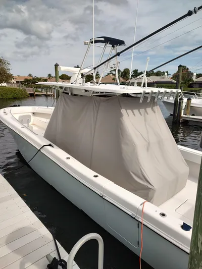  Yacht Photos Pics 2016 Invincible 39 Open Fisherman boat docked, covered, with fishing rods, under cloudy sky.