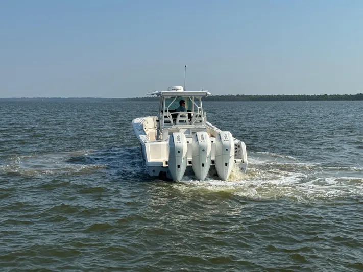  Yacht Photos Pics 2024 Sailfish 360 CC boat cruising on open water with triple outboard engines.
