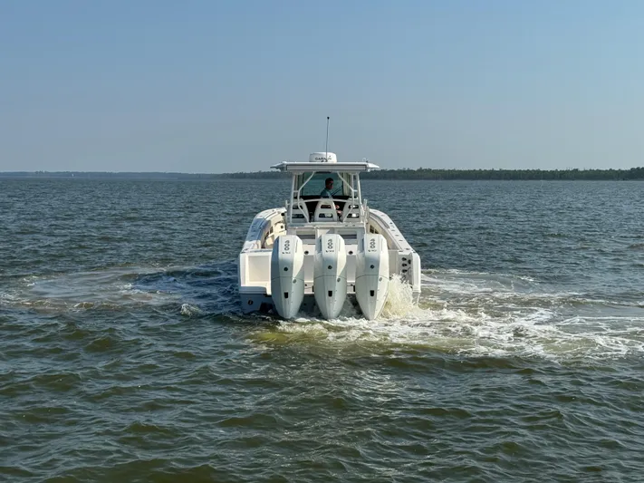  Yacht Photos Pics 2024 Sailfish 360 CC boat cruising on open water, rear view.