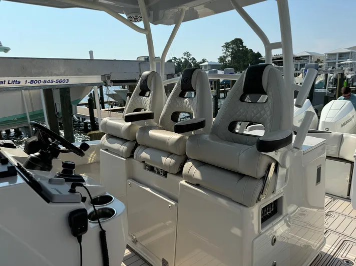  Yacht Photos Pics 2024 Sailfish 360 CC boat interior with three cushioned seats and steering console.