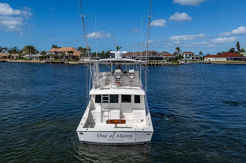 One Of Many Yacht Photos Pics 1999 Post 50 Convertible yacht on water, clear sky, waterfront homes in background.