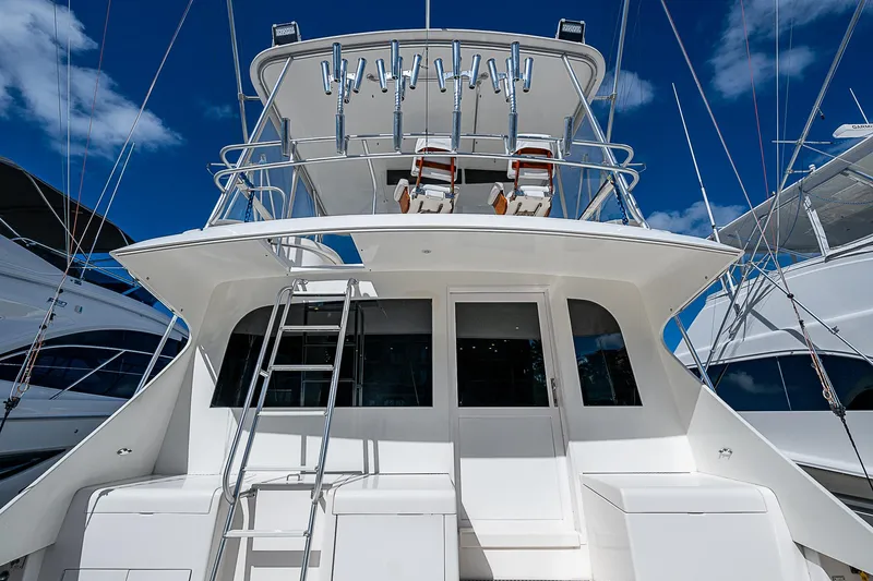 One Of Many Yacht Photos Pics 1999 Post 50 Convertible yacht, rear view with ladder and upper deck, under blue sky.
