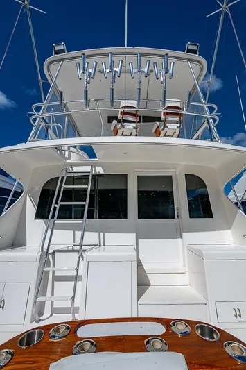 One Of Many Yacht Photos Pics 1999 Post 50 Convertible yacht with fishing rods and ladder under clear blue sky.