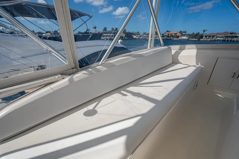 One Of Many Yacht Photos Pics Interior view of a 1999 Post 50 Convertible yacht with white seating and marina backdrop.
