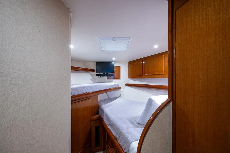 One Of Many Yacht Photos Pics Interior of 1999 Post 50 Convertible yacht with cozy twin beds and wooden cabinetry.