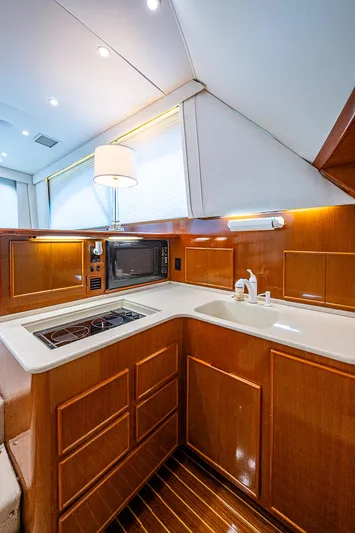 One Of Many Yacht Photos Pics Luxurious 1999 Post 50 Convertible yacht kitchen with modern amenities and wood cabinetry.