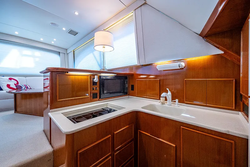 One Of Many Yacht Photos Pics Luxurious 1999 Post 50 Convertible yacht kitchen with modern amenities and elegant wood cabinetry.