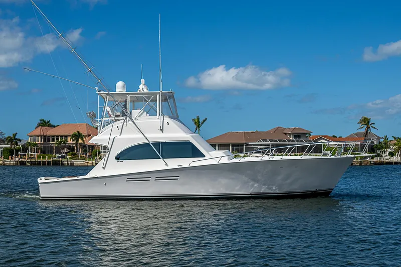 One Of Many Yacht Photos Pics 1999 Post 50 Convertible yacht cruising on a sunny day near waterfront homes.