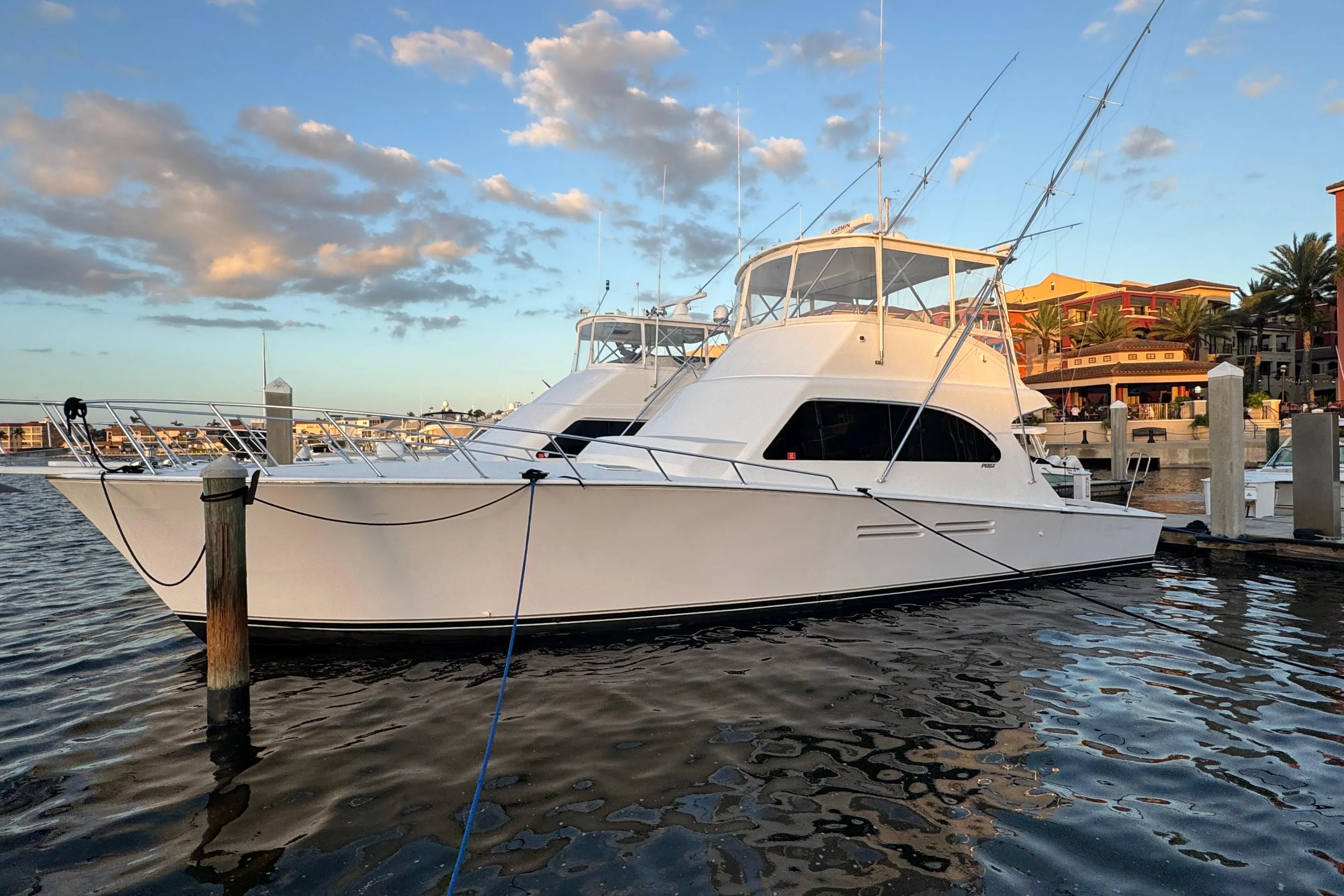 1999 Post 50 Convertible yacht docked at marina under blue sky.