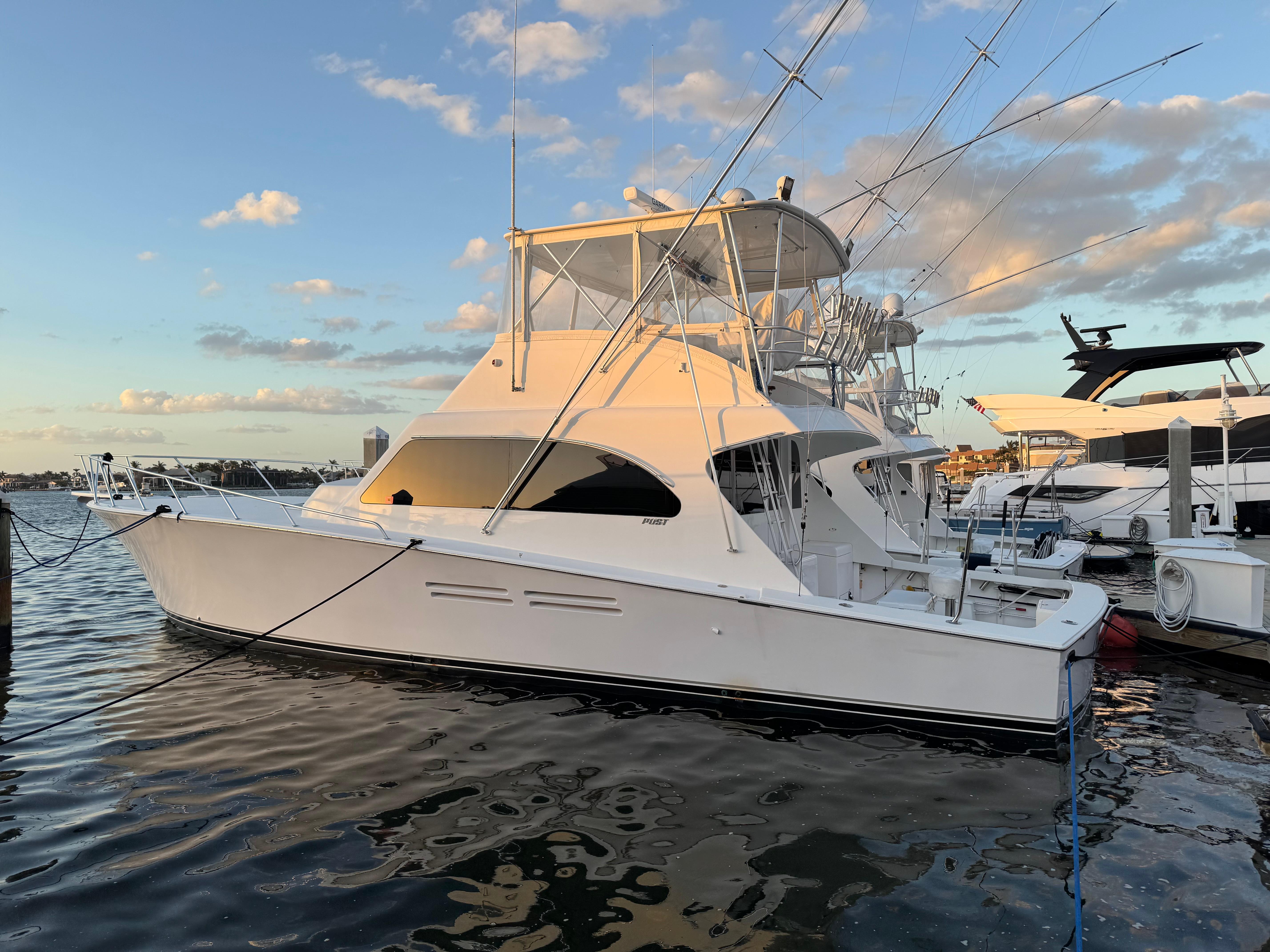 1999 Post 50 Convertible yacht docked at marina during sunset.