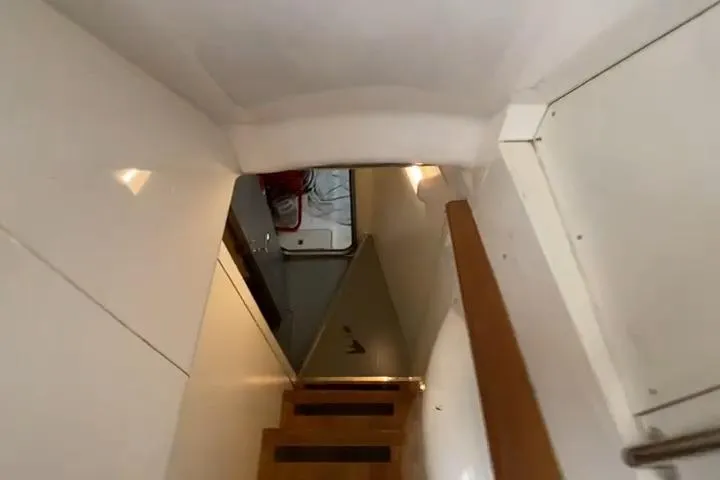  Yacht Photos Pics Stairway inside 2007 Princess 21M yacht, featuring wooden steps and white walls.