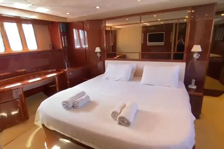  Yacht Photos Pics Luxurious bedroom interior of 2007 Princess 21M yacht with elegant wood finish and cozy bedding.