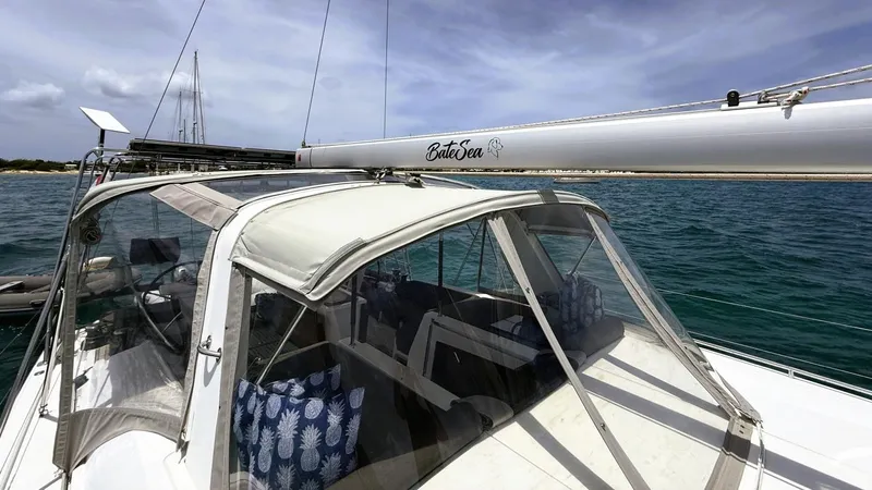 Batesea Yacht Photos Pics 2020 Beneteau Oceanis 46.1 sailboat with canopy, anchored in clear blue waters.