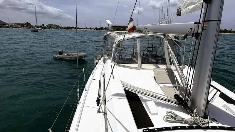 Batesea Yacht Photos Pics 2020 Beneteau Oceanis 46.1 yacht anchored in calm waters, with a small dinghy nearby.
