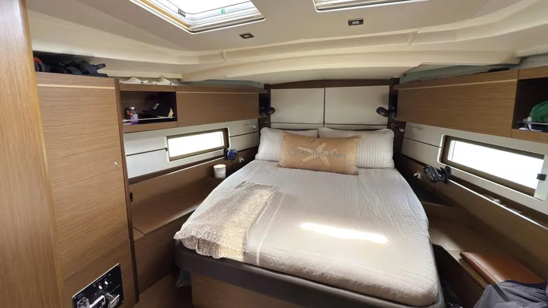 Batesea Yacht Photos Pics Luxurious cabin interior of 2020 Beneteau Oceanis 46.1 yacht with cozy bed and wooden finish.