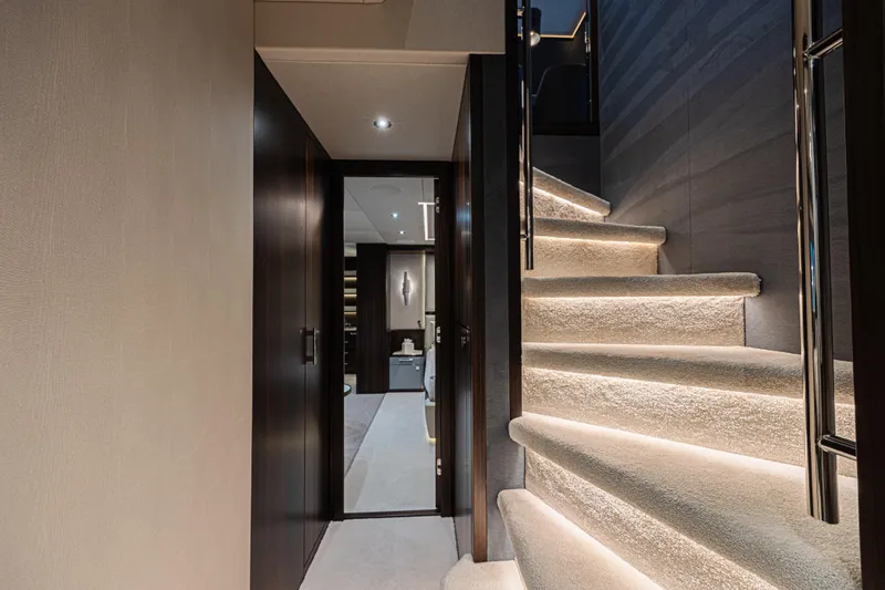 Hideout Yacht Photos Pics Luxurious interior staircase of 2025 Sunseeker 88 Yacht with elegant lighting.