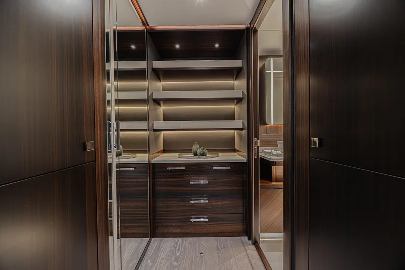 Hideout Yacht Photos Pics Luxurious interior of 2025 Sunseeker 88 Yacht with elegant wood cabinetry and shelving.
